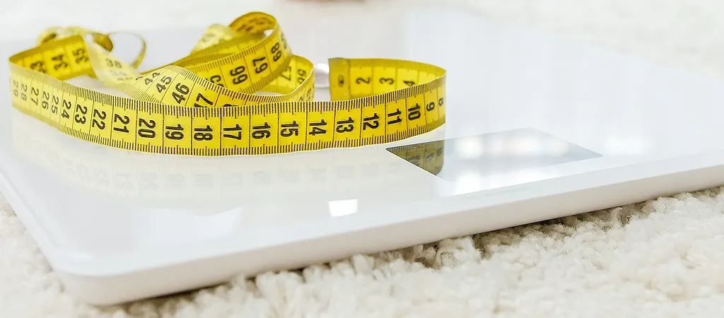 BMI kalkulátor: Mérleg és sárga mérőszalag puha szőnyegen, a diéta és egészséges életmód szimbóluma.